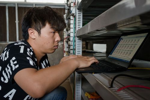 Close-up view of a cryptocurrency miner installing a mining rig in a hosting facility